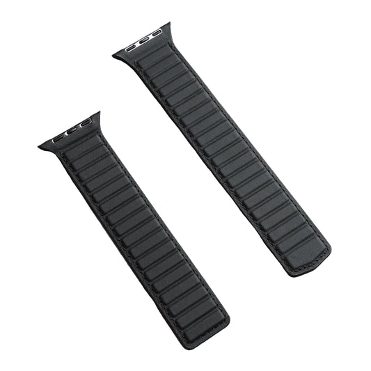 Two black watch straps on a gray concrete surface